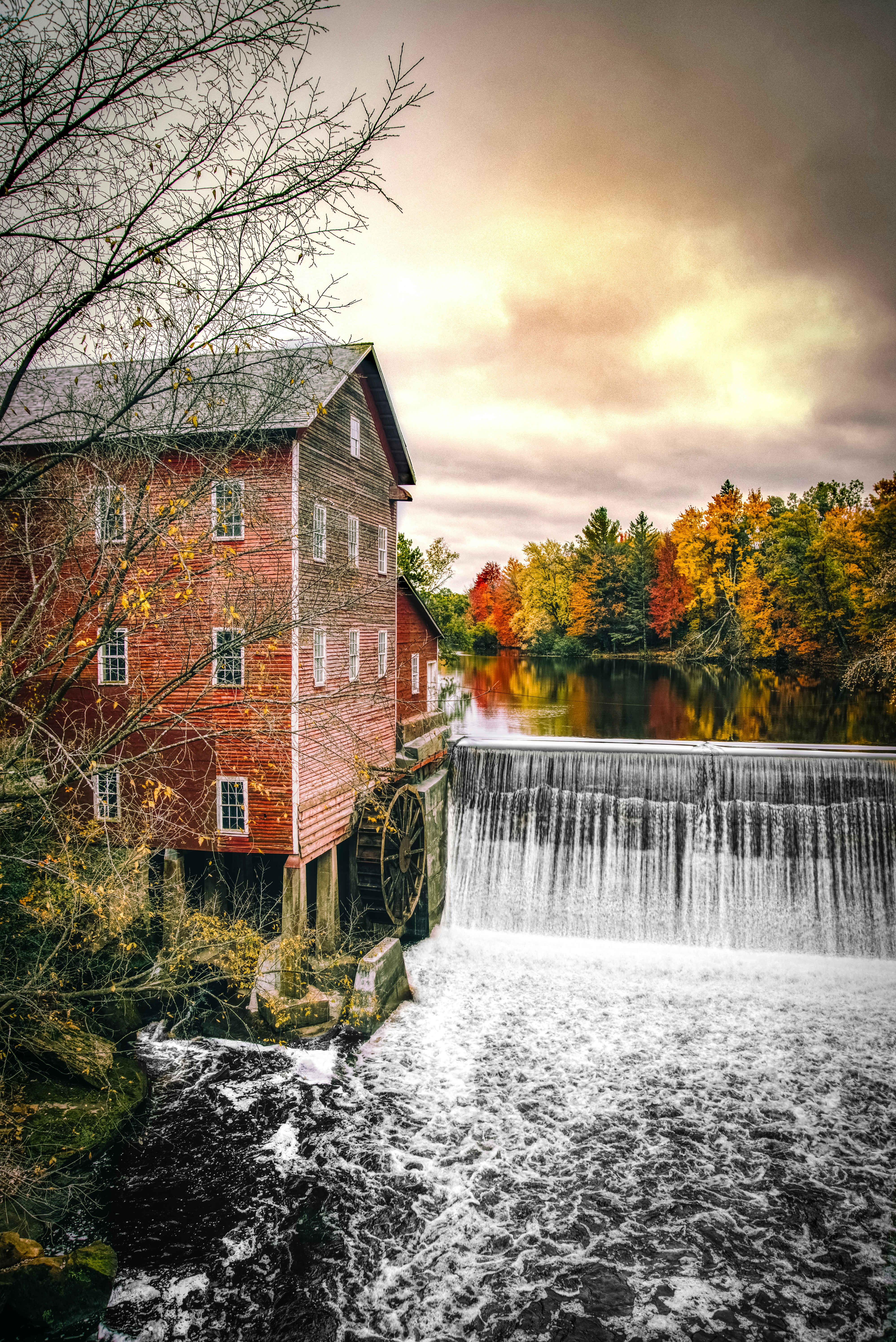 watermill near waterfall during cloudy day
